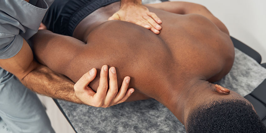 Belmont auto accident forms for chiropractor adjusting patient's shoulder to relieve pain